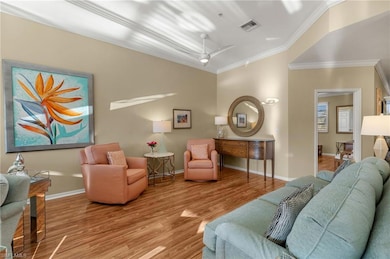 Living area featuring baseboards, crown molding, v