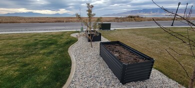 View of grassy yard featuring a garden and a mountain view