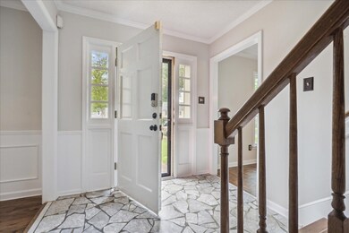 Foyer with crown molding and light wood-type floor