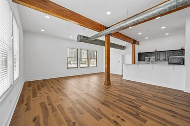 Unfurnished living room featuring dark wood-type f