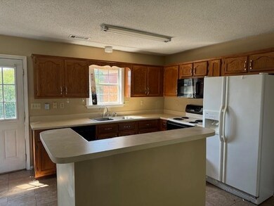 Kitchen with light tile patterned floors, sink, a 