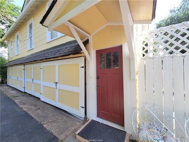 View of exterior entry featuring a shingled roof