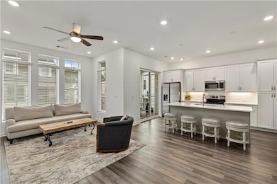 Living room featuring ceiling fan, dark hardwood /
