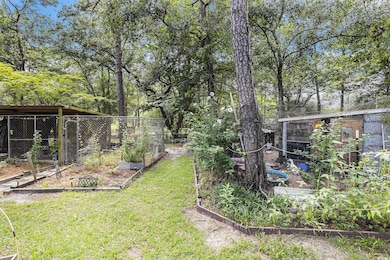 View of grassy yard with a vegetable garden