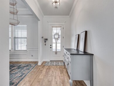 Entrance foyer featuring ornamental molding and li