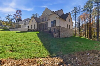 View of side of home featuring a lawn, stone siding, and board and batten siding
