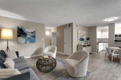 Living room with a textured ceiling and light wood