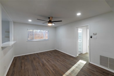 Unfurnished room featuring ceiling fan and dark wo