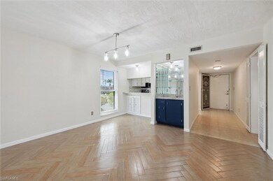 Unfurnished living room featuring a sink and baseboards