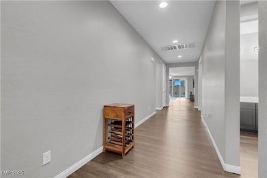 Hall featuring wood finished floors, baseboards, a