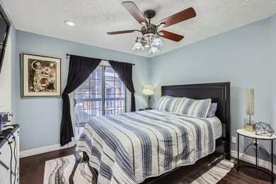 Bedroom with ceiling fan, dark hardwood / wood-sty