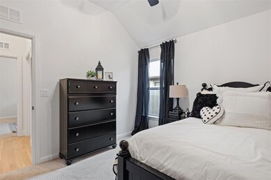 Bedroom featuring vaulted ceiling, baseboards, ceiling fan, and light colored carpet