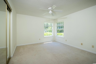 Spare room with carpet floors, a ceiling fan, base