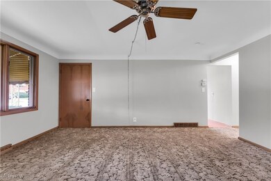 Carpeted empty room with ceiling fan