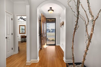 Corridor with arched walkways, light wood-type flo