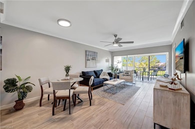 Living room featuring crown molding, light hardwoo