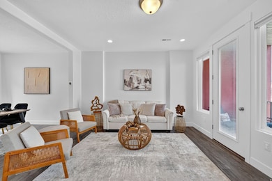 Living room featuring wood finished floors, a textured ceiling, and recessed lighting