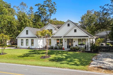 Modern farmhouse with covered porch, a front yard,
