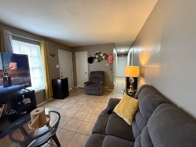Living area with light tile patterned floors and baseboards