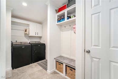 Mudroom with ornamental molding, washing machine and clothes dryer, and recessed lighting