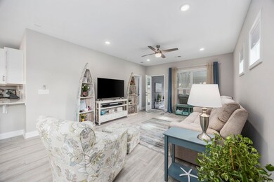 Living room with ceiling fan and light hardwood / wood-style floors