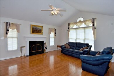 The living room offers vaulted ceiling and gas log