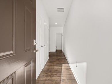 Hallway with dark wood-type flooring and recessed lighting