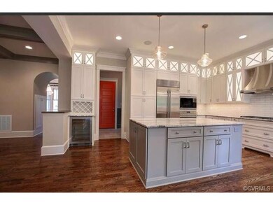 The kitchen features hardwood floors, large island
