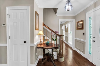Entryway with dark wood-style flooring, stairs, a 