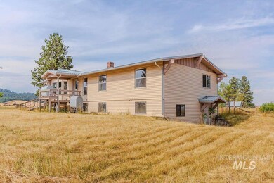 Rear view of house featuring a chimney, heating fuel, a yard, and board and batten siding