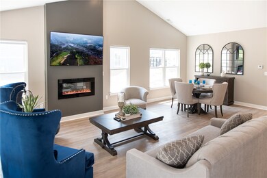 Spacious Great Room with Fireplace, Dining Area, & Faux Wood Plank Floors