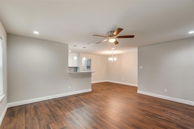 Unfurnished living room featuring dark wood-type f