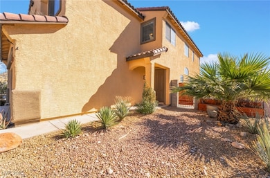 View of side of home with a tiled roof and stucco