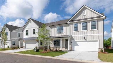 Modern farmhouse featuring driveway, board and batten siding, and a standing seam roof