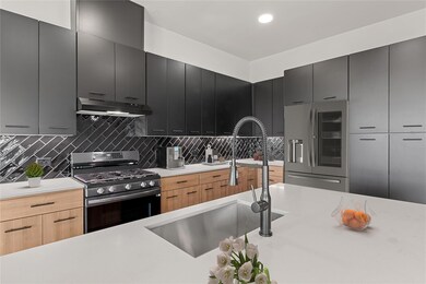 Kitchen with stainless steel refrigerator with ic