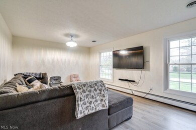 Living room featuring plenty of natural light, light hardwood / wood-style floors, and a baseboard heating unit