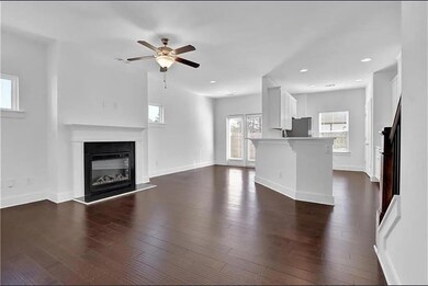 Unfurnished living room with ceiling fan, dark woo