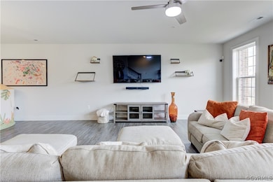 Living room featuring ceiling fan and hardwood / w