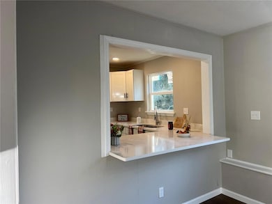 Kitchen with sink, ornamental molding, kitchen peninsula, and white cabinets