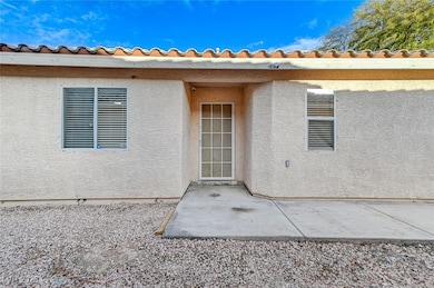 Property entrance with a patio and stucco siding