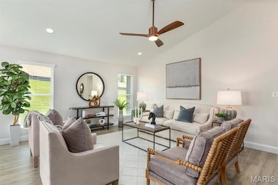 Living room featuring ceiling fan, high vaulted ceiling, and light wood-type flooring