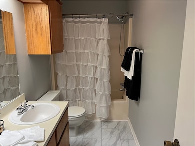 Bathroom with double, sink vanity, toilet, shower