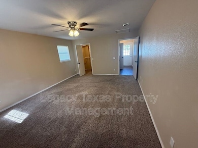 Unfurnished bedroom featuring carpet, a walk in closet, and a ceiling fan