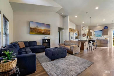 Living area featuring dark wood-type flooring, recessed lighting, and high vaulted ceiling