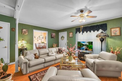 Living room with wood-type flooring and ceiling fa