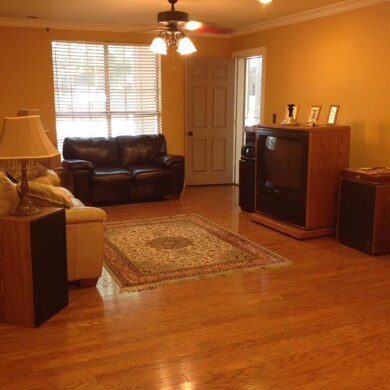 Spacious Great Room with Hardwood Flooring, Crown Molding and Door to Screened Porch!