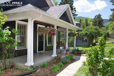 Property entrance with covered porch, a shingled roof, and a mountain view