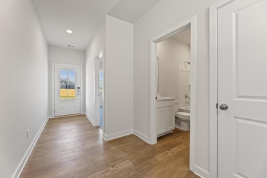 Hallway with light wood-style floors, baseboards, 