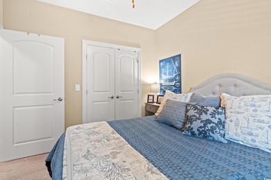 Carpeted bedroom featuring a closet and vaulted ceiling