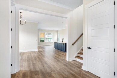 Hallway with sink, crown molding, and light hardwo